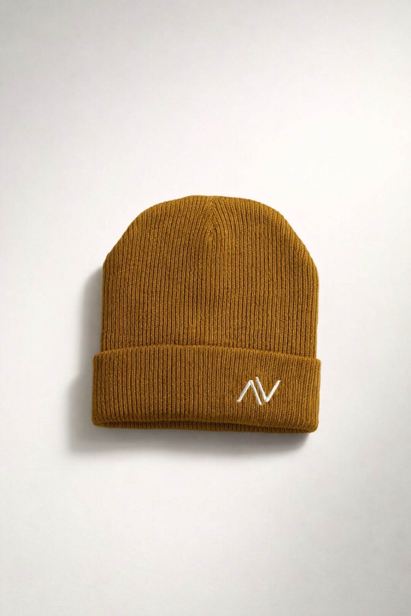 Side view of ribbed knit beanie with embroidered logo showing cuffed design and stretch fit
